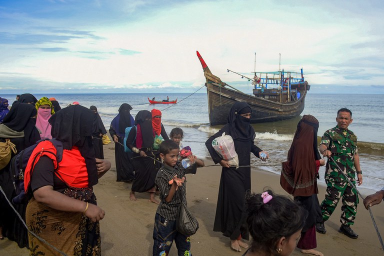 ENG_BUR_MyanmarRefugees_11162022.2.jpg Rohingya migrants are escorted after their boat carrying 119 people landed on the coast of Bluka Teubai, North Aceh, Indonesia, on November 16, 2022, after surviving a five week journey at sea. Credit: AFP