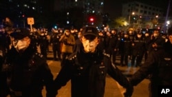 Chinese policemen form a line to block off protesters in Beijing, Nov. 27, 2022.