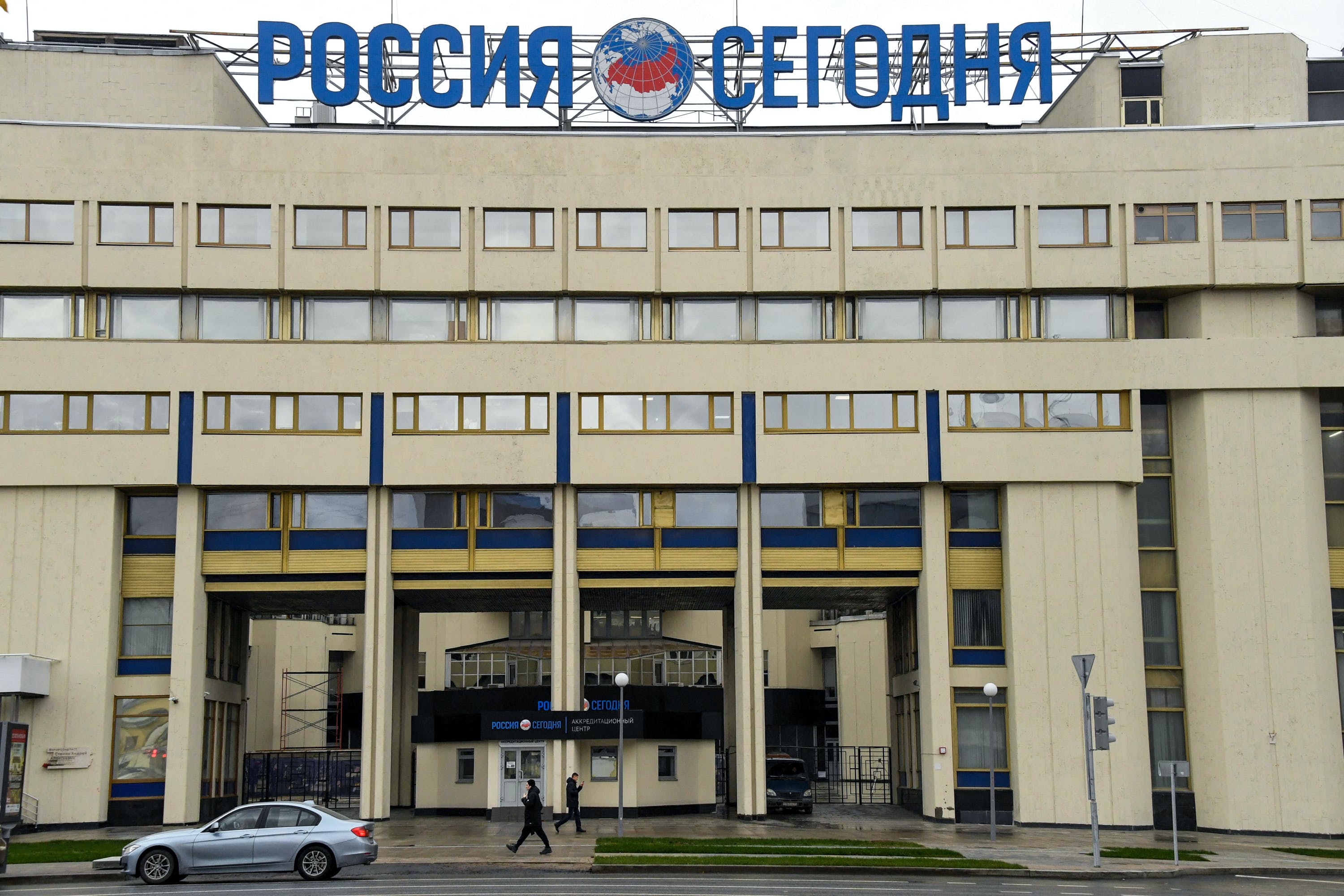 People walk past the Moscow headquarters of Russia's Rossiya Segodnya state media group, on November 12, 2017.