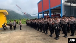 This handout photo taken on Jan. 16, 2023 and released by Morowali Police shows police taking up positions after two workers, including a Chinese national, were killed at a nickel smelting plant in Morowali, Sulawesi after a riot broke out during a protest over labor conditions. Morowali Police via AFP