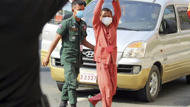 Cambodian environmental activist Thun Ratha [right], seen in 2021 outside the Phnom Penh Municipal Court before his conviction on incitement charges, says he will not sell out for a government position. Credit: RFA