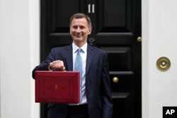 Britain's Chancellor of the Exchequer Jeremy Hunt poses for the media with his traditional Red ministerial box as he leaves 11 Downing Street for the House of Commons to deliver the Budget in London, March 15, 2023.