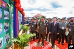 Cambodian Defense Minister Tea Banh, center left, and Chinese Ambassador to Cambodia Wang Wentian, center right, visit the site of the groundbreaking ceremony for a shipyard repairing and restoration workshop in Ream Cambodian Naval Base of Sihanoukville, June 8, 2022. (Cambodia's Fresh News via AP)