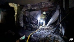 Firefighters inspect the ruins of houses destroyed in a fire in Jakarta, Indonesia, March 3, 2023.