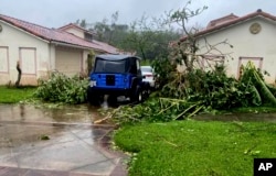 In this photo provided by the U.S. Coast Guard, downed tree branches litter a neighborhood in Yona, Guam, May 25, 2023, after Typhoon Mawar passed over the island.
