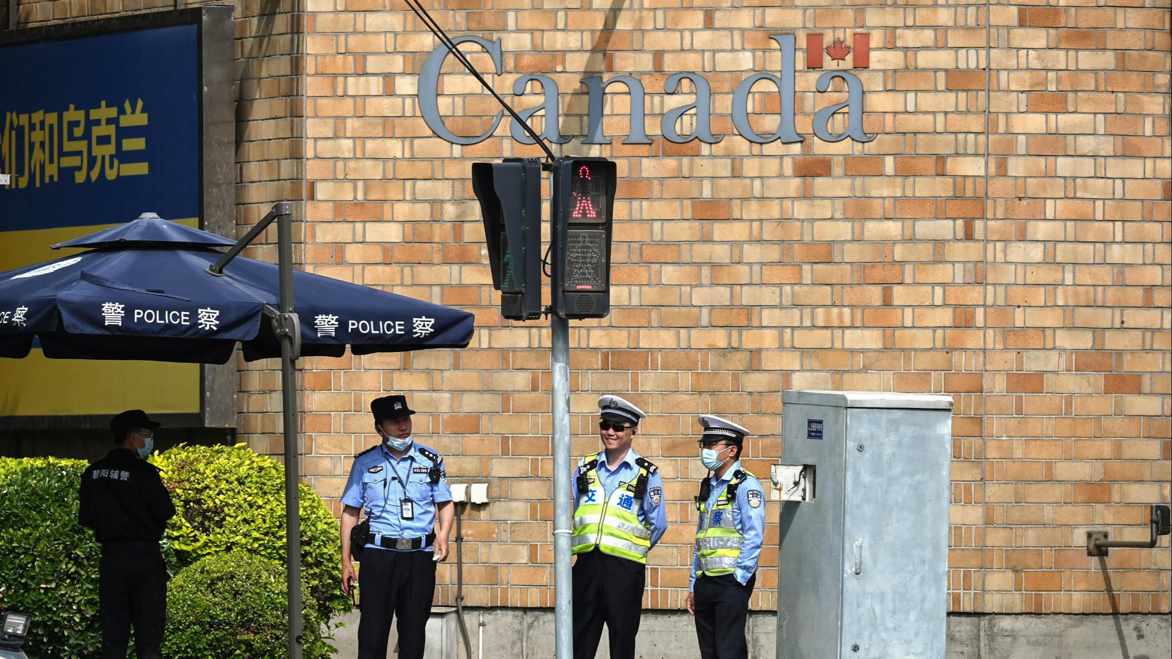 Police stand outside the Canadian embassy in Beijing