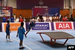 Thailand's Jutatip Kuntatong (C) competes with teammate Suphawadi Wongkhamchan (L) in their women's doubles group stage teqball match against Cambodia at the 32nd Southeast Asian Games (SEA Games) in Phnom Penh on May 6, 2023.