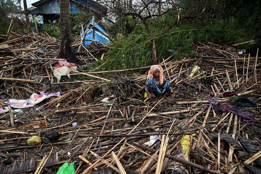 3mocha.jpg A Rohingya woman sits amid the shattered remains of her home in the Basara refugee camp in Sittwe, Myanmar, on Tuesday, May 16, 2023. Credit: AFP