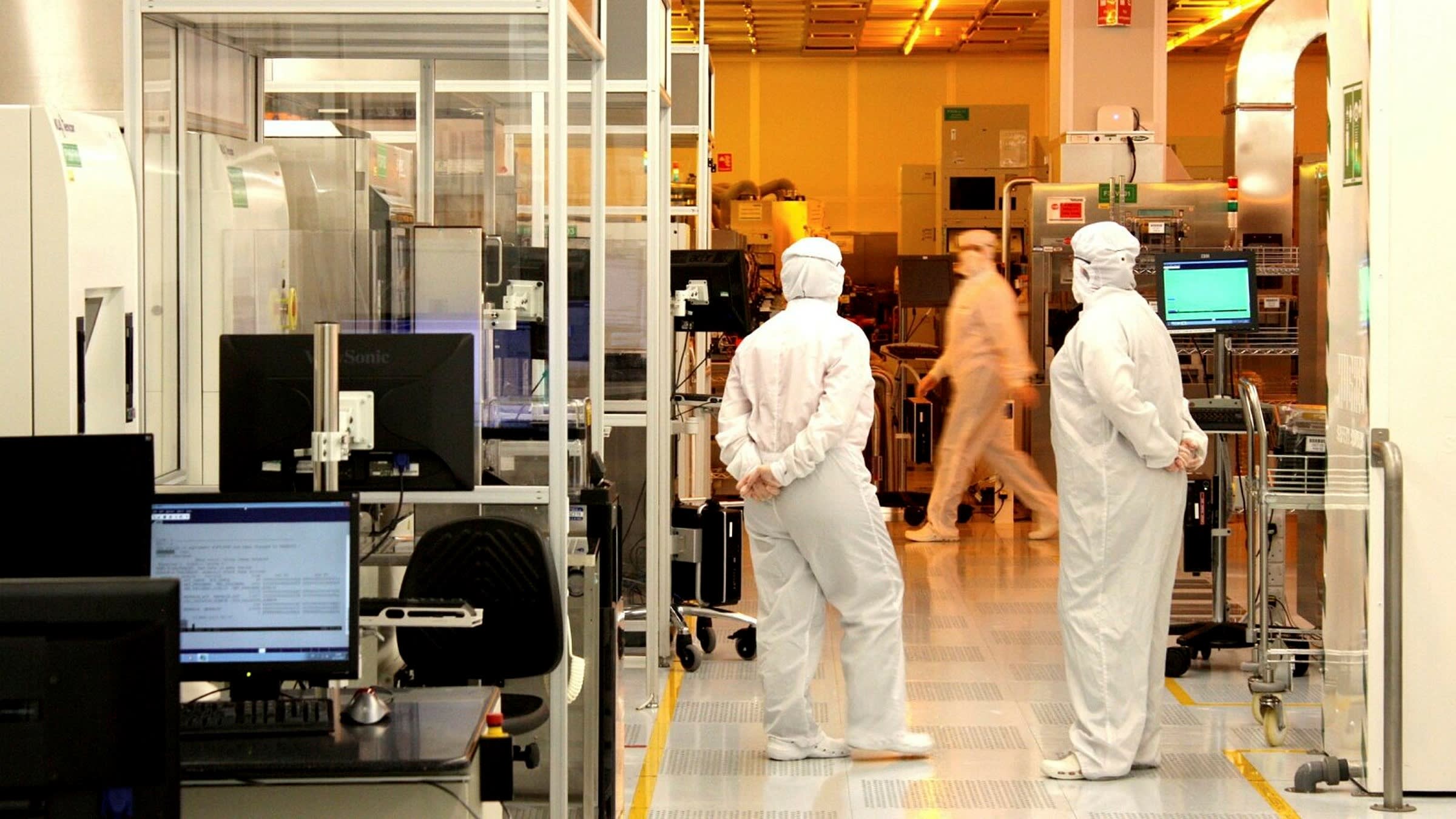 People wear protective suits in a wafer fabrication lab in Wales