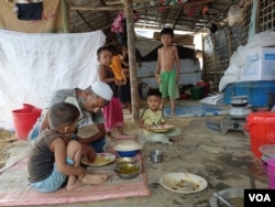 A Rohingya family eats at their shanty in Cox's Bazar camp, Bangladesh, March 18, 2023. (Noor Hossain/VOA)