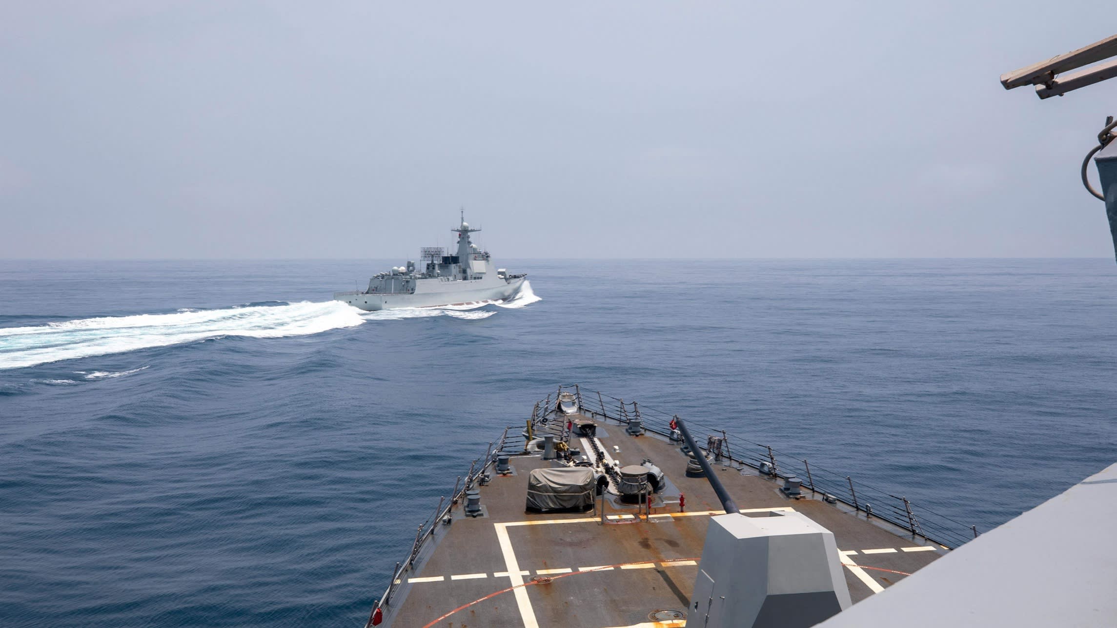 A US Navy handout of the Arleigh Burke-class guided-missile destroyer USS Chung-Hoon observing the Chinese PLA Navy vessel Luyang III, top, while on a transit through the Taiwan Strait