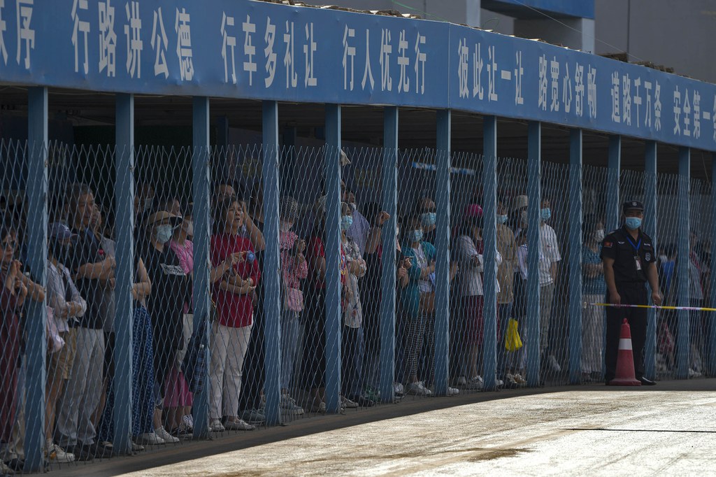 ENG_CHN_StudentExam_06072023_02.JPG Parents stand and watch as students enter a school to sit for the gaokao exam in Beijing, June 7, 2023. Credit: Andy Wong/AP