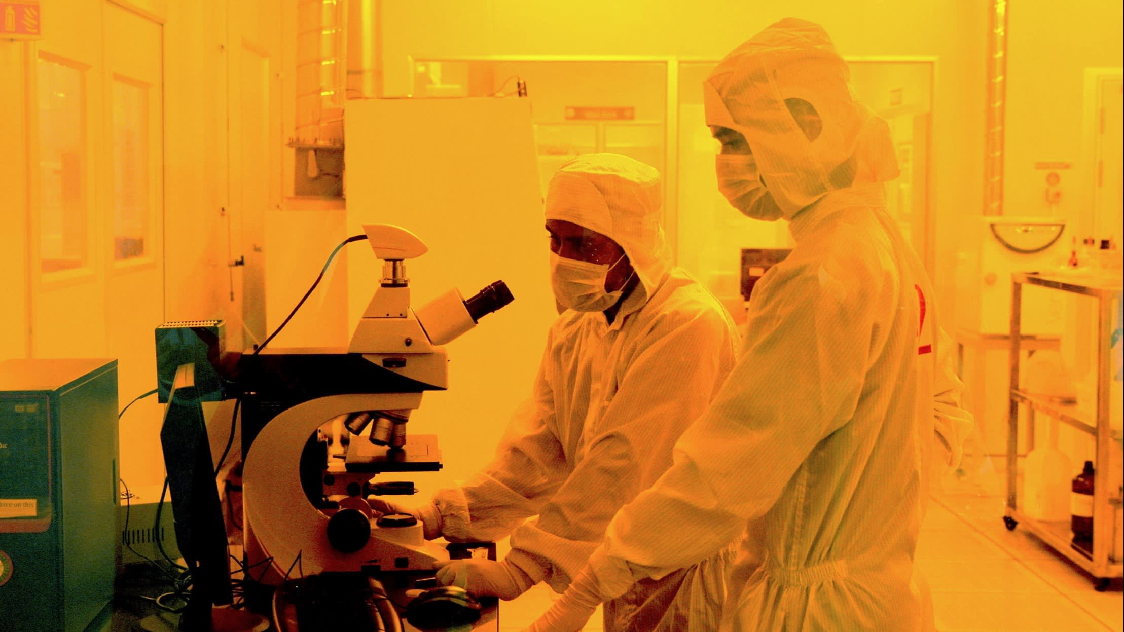 Researchers wearing hazmat suits work inside a semiconductor fabrication lab in Bangalore