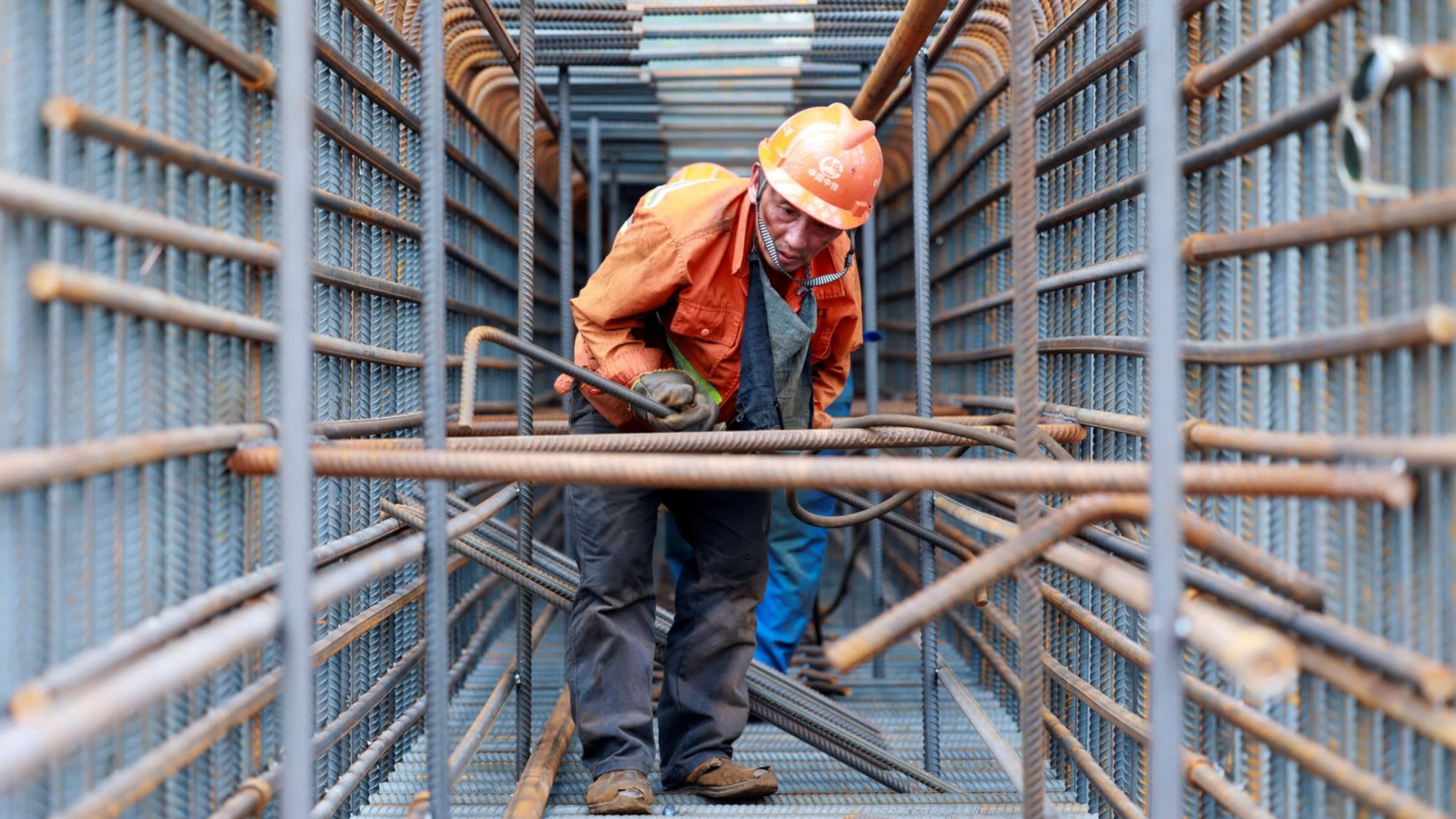 A worker prepares steel bars at a site in China’s eastern Jiangsu province