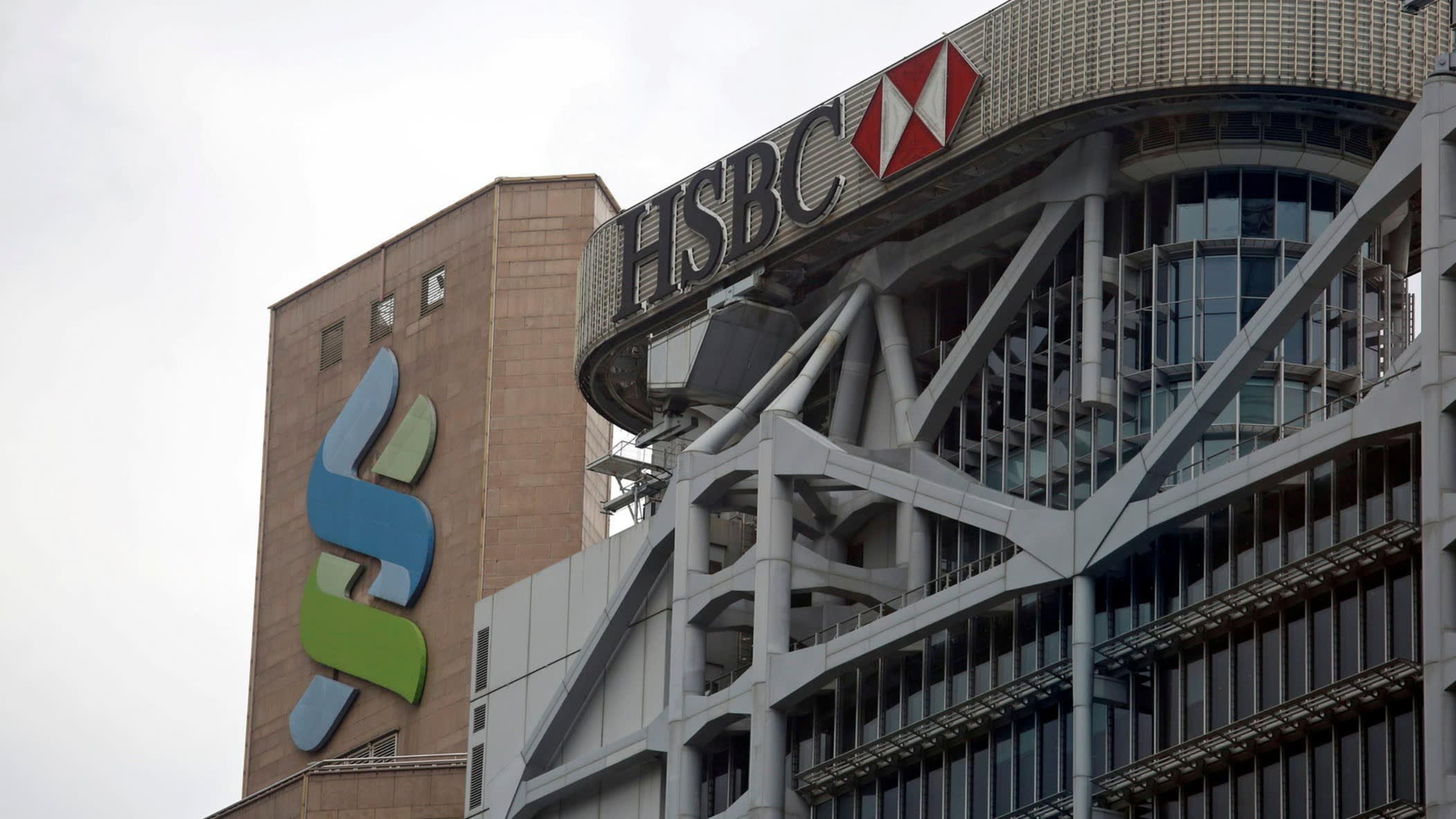 Logos of HSBC and Standard Chartered at their headquarters in Hong Kong