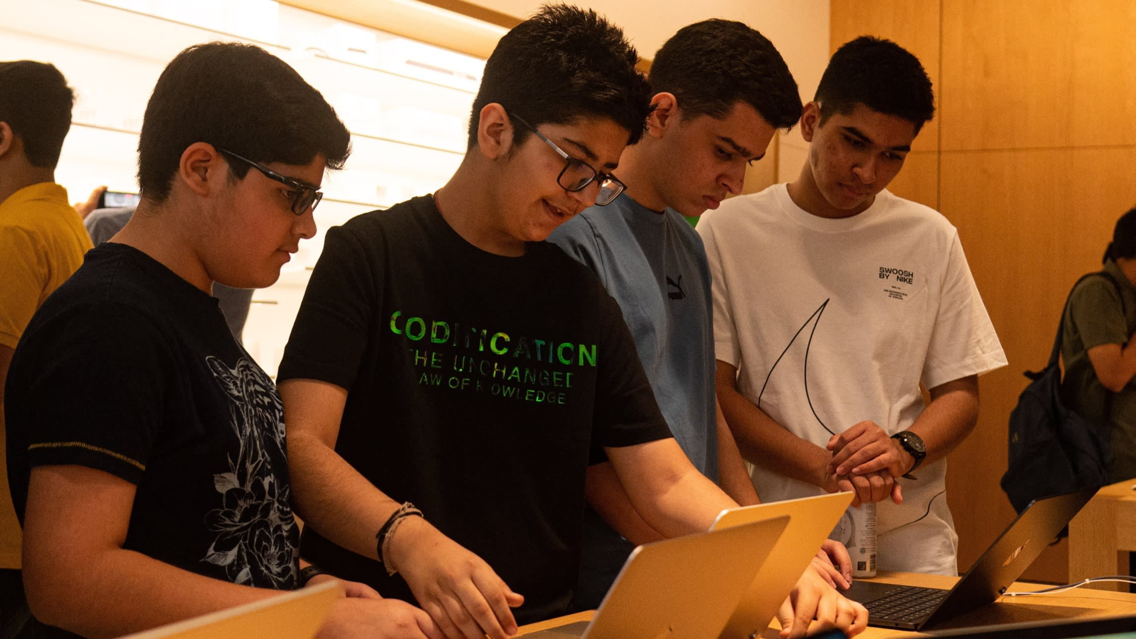 Young Indians looking at laptops in an Apple shop