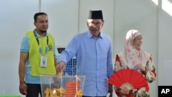 Malaysian Prime Minister Anwar Ibrahim, center, casts his ballot during the election at a polling station in Seberang Perai, Penang state, Malaysia, Aug. 12, 2023.