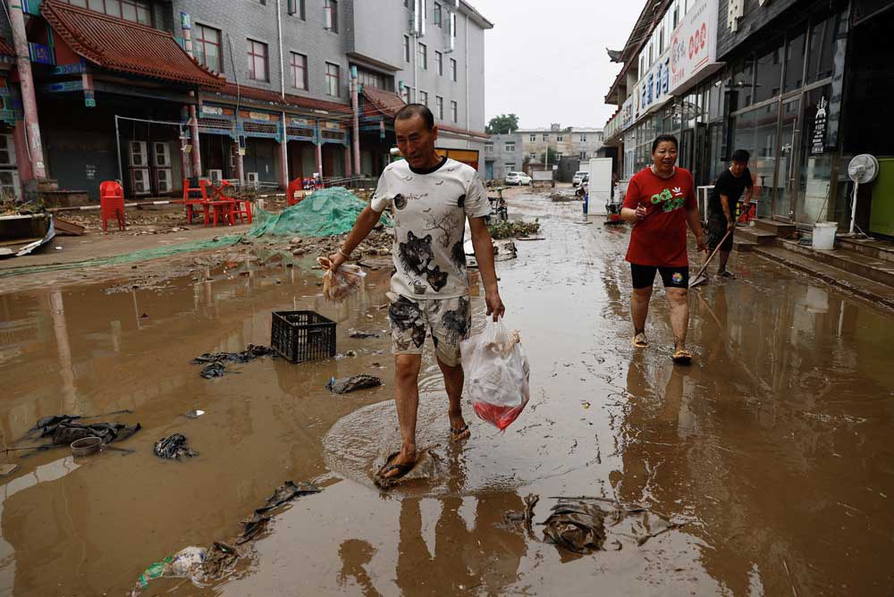 embed1.jpg People move out items from stores after the remnants of Typhoon Doksuri brought rains and floods in Beijing, China, Wednesday, Aug. 2, 2023. Credit: Tingshu Wang/Reuters