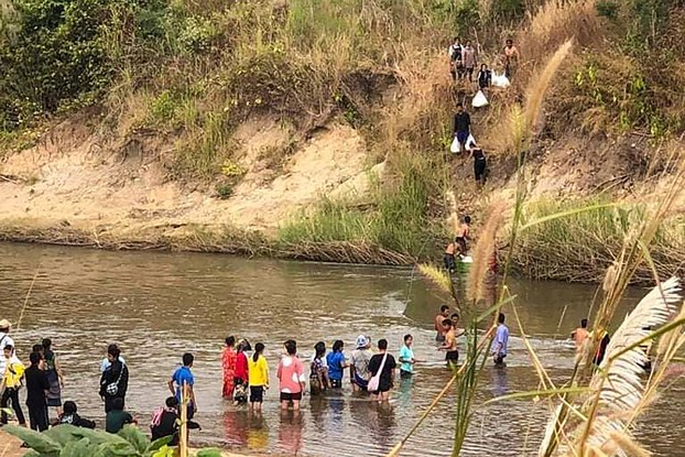 ENG_BUR_KNU-NCA_08102023.2.jpg Civilians fleeing fighting between the Myanmar military and the Karen National Union cross a river in eastern Myanmar's Kayin state, along the Thai-Myanmar border, Dec. 25, 2021. Credit: AFP