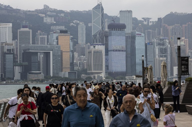 ENG_CHN_HKTaiwan_07272023.img02.jpg Mainland tourists and other people walk along the promenade next to Victoria Harbour in Hong Kong. Credit: AFP