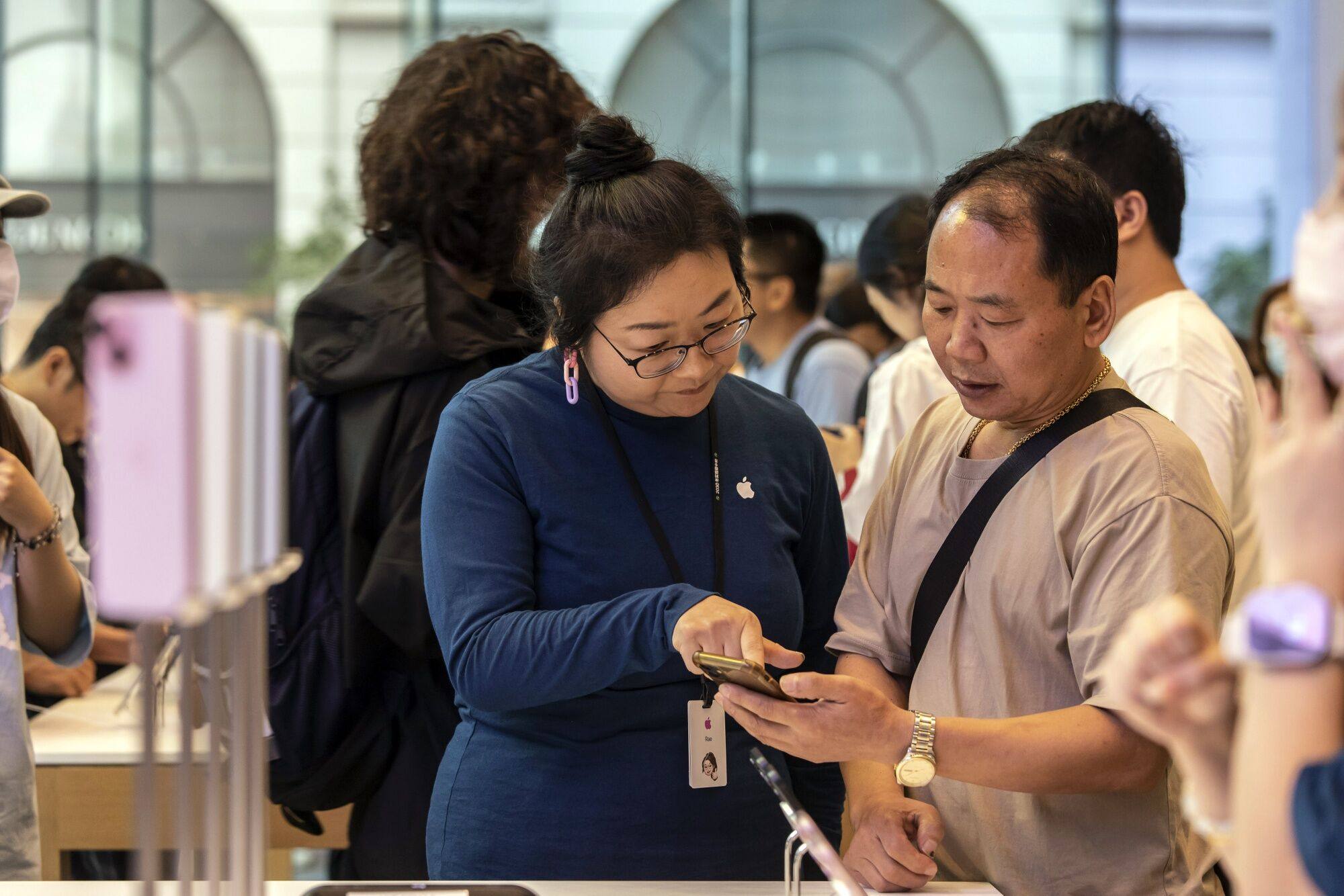 A customer checks out the new iPhone at an Apple store in Shanghai on Friday. Photo: Bloomberg