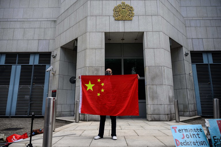 ENG_CHN_HKConsulates_09202023.3.jpg An activist holds the national flag of China after a pro-Beijing group gathered outside the British Consulate-General in Hong Kong to protest against the use of the British National (Overseas) passport on Feb. 1, 2021. Credit: Anthony Wallace/AFP