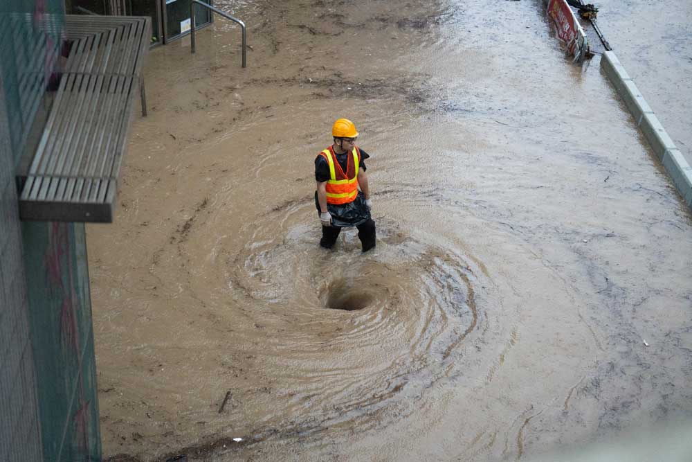 Embed-1-000_33UL9HY.jpg A woman walks down a flooded back alley in Hong Kong, Friday, Sept. 8, 2023. Credit: Mladen Antonov/AFP