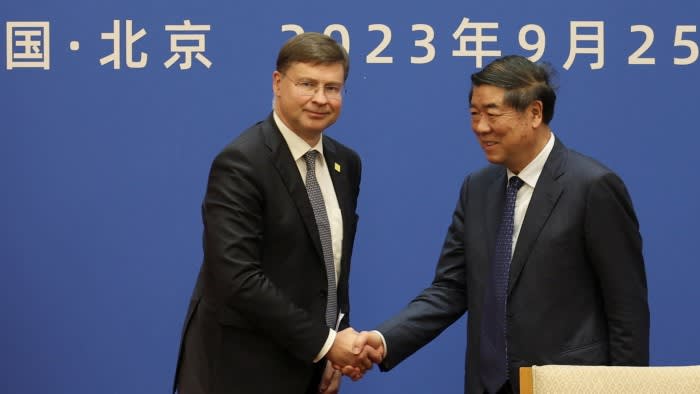 Dombrovskis and He shaking hands