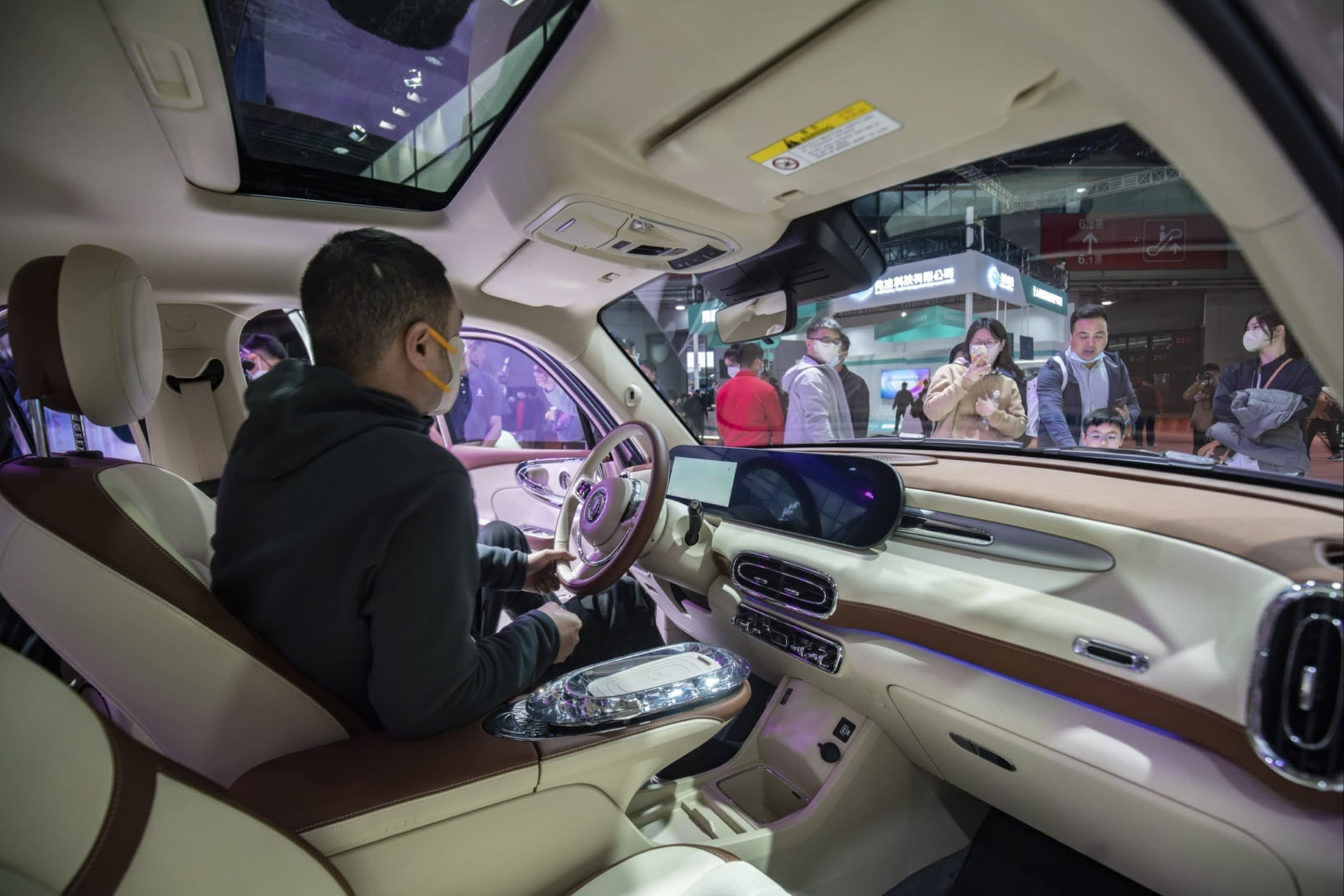 A visitor sits in a Great Wall Motor Ora Ballet Cat electric vehicle at the Shanghai Auto Show