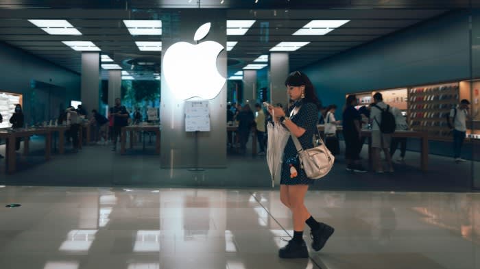 A woman walks past an Apple Store in Shanghai