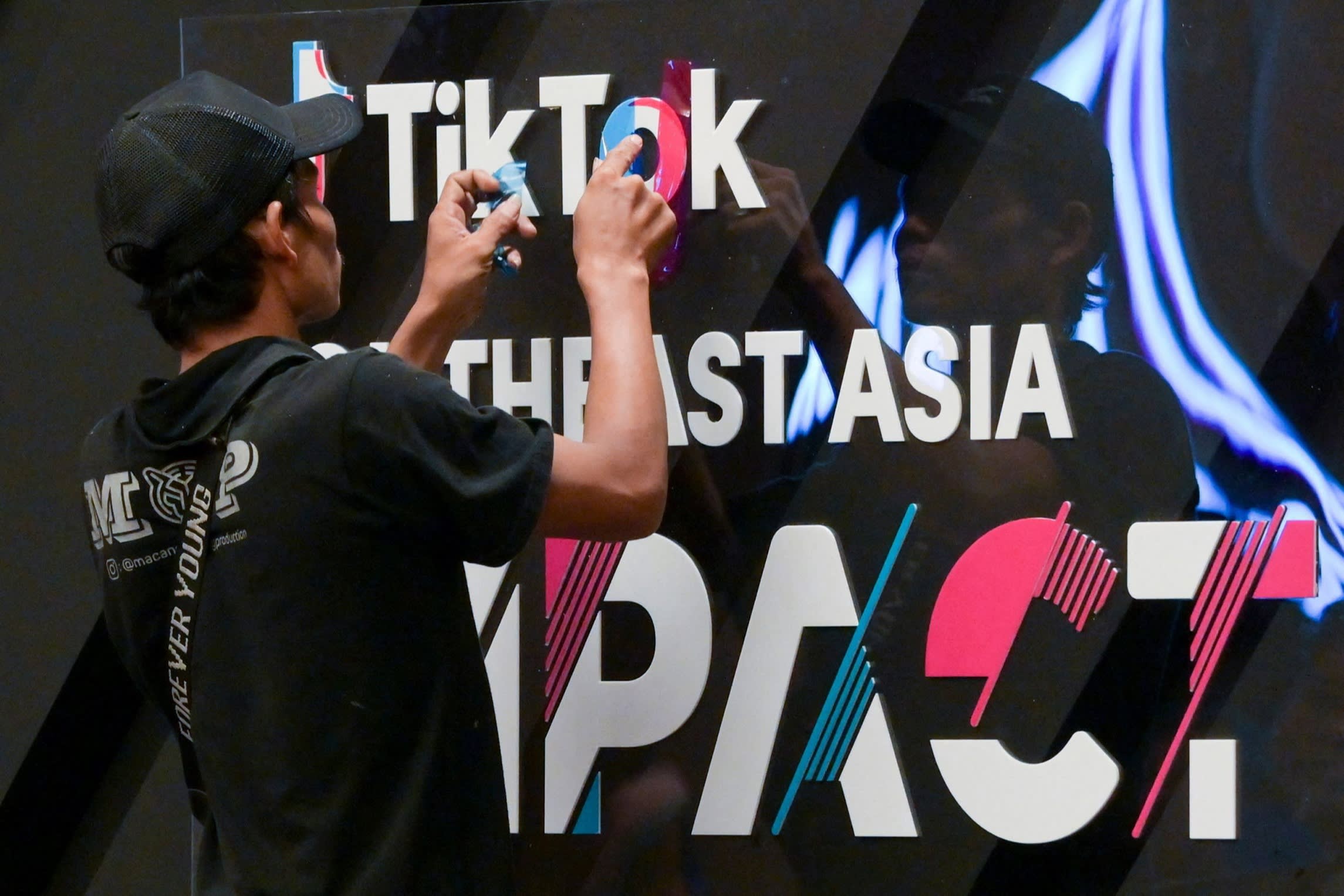 A worker finishes signage before the TikTok Southeast Asia Impact Forum 2023, which was held in Jakarta in June.