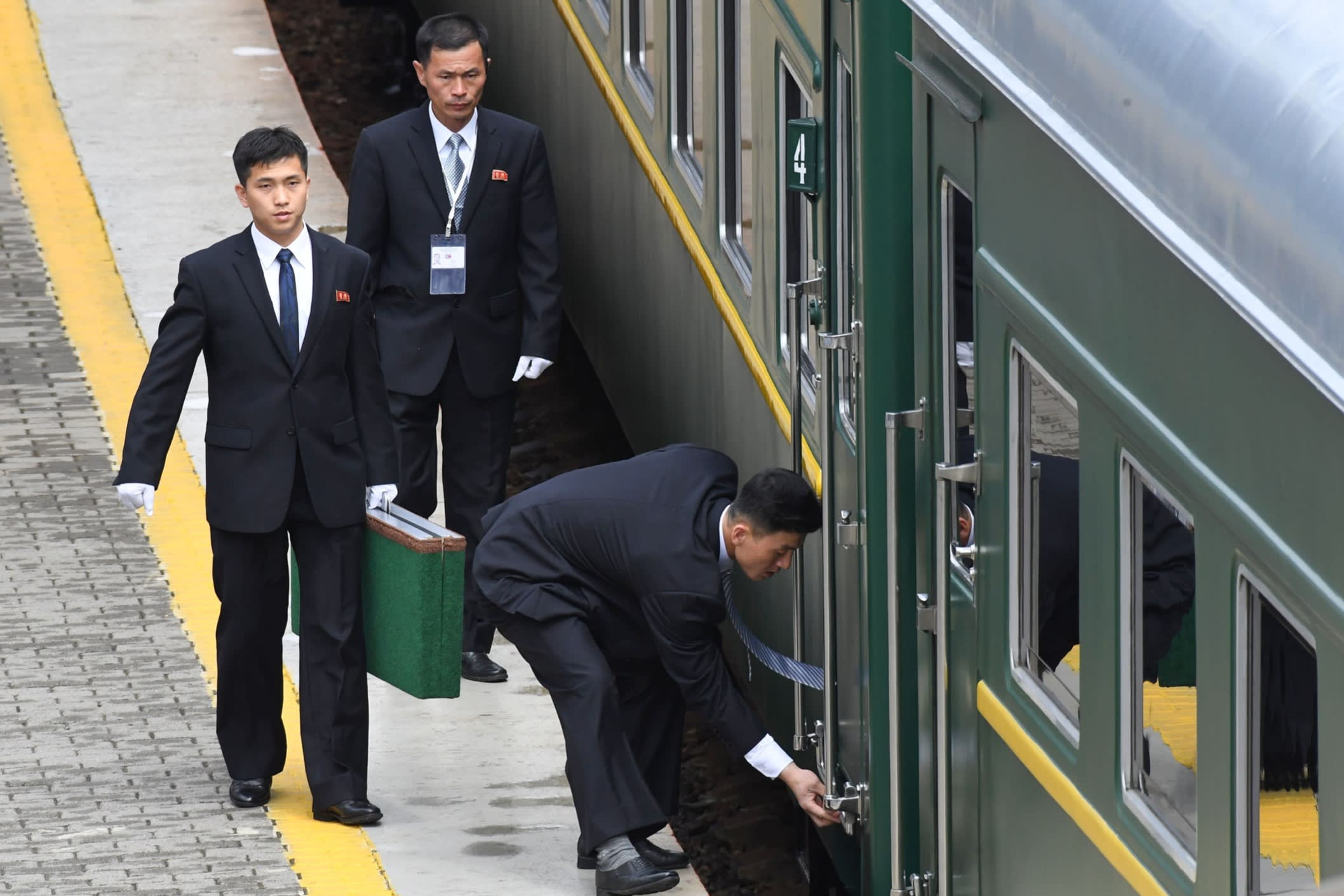 Suited officials securing a door of the train