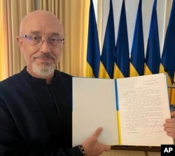 In this photo provided by the Ukrainian Parliament Press Office, Ukrainian Defense Minister Oleksii Reznikov shows his resignation letter addressed to the parliamentary speaker in Kyiv, Ukraine, Sept. 4, 2023.