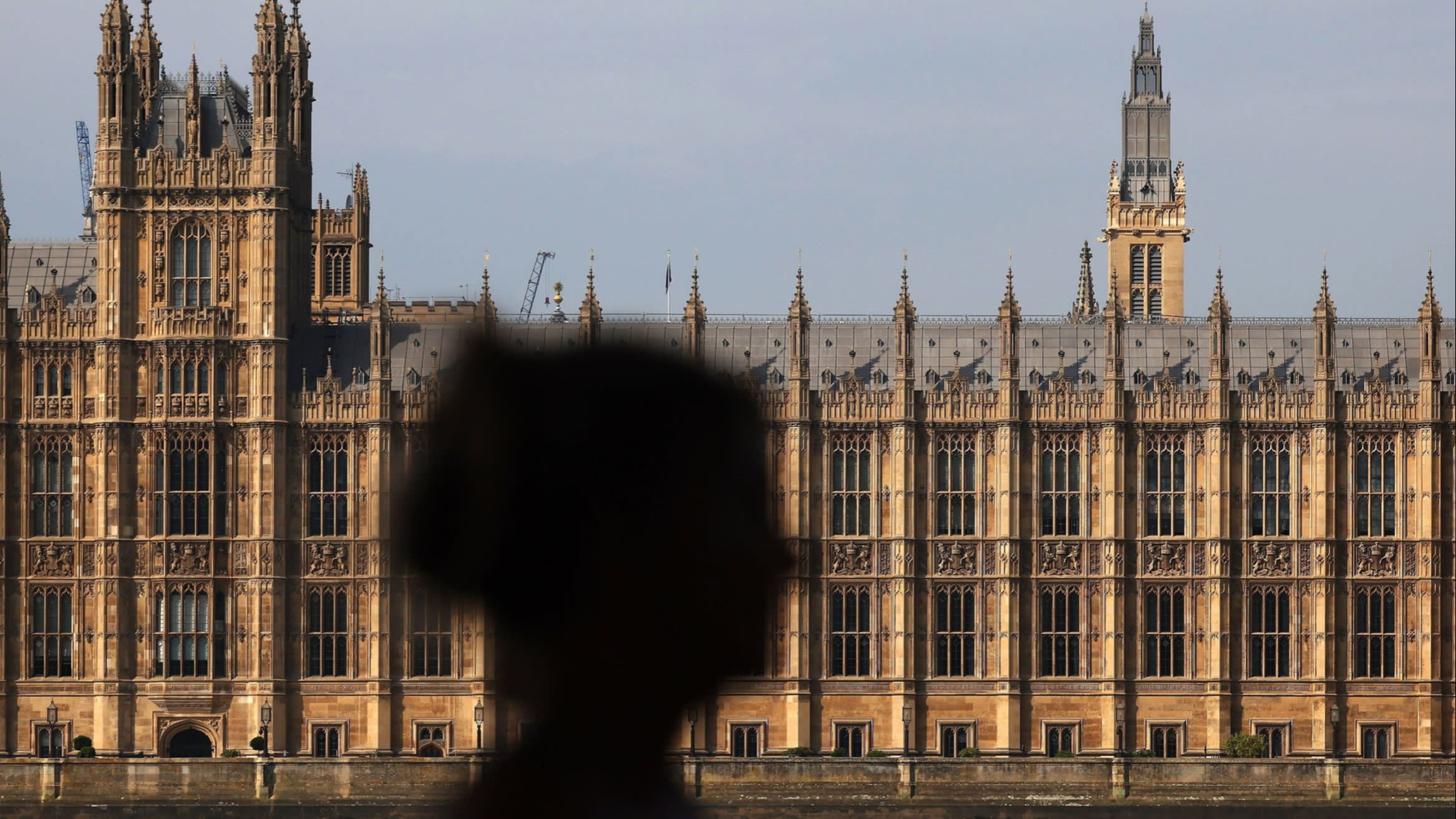 The shadow of a person in front of parliament buildings in Westminster, London