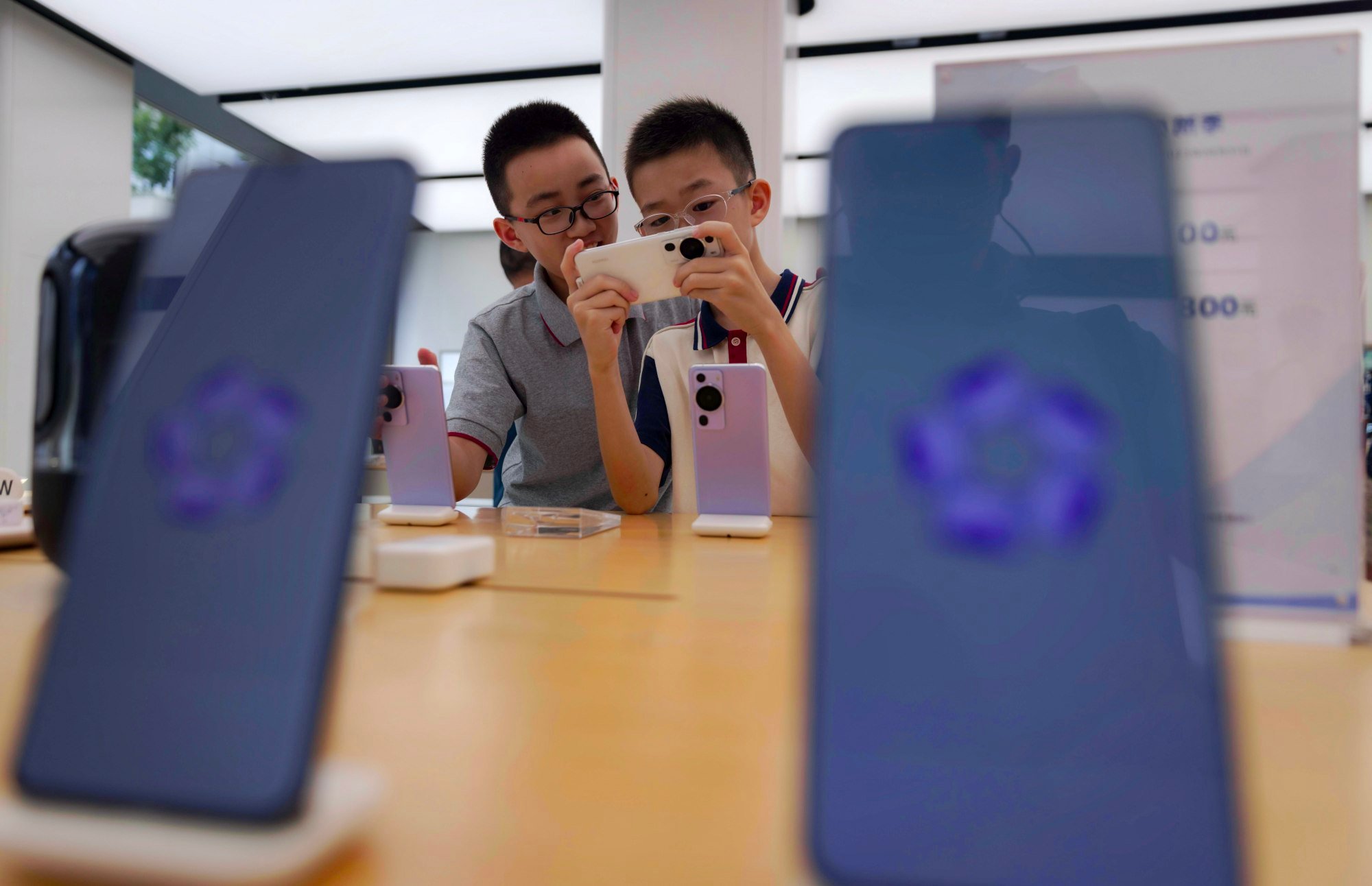 Children play with smartphones on display in a Huawei store in Shanghai. Photo: EPA-EFE tech war us seeks details on made in china huawei chip in mate 60 pro smartphone possibly made by smic 2