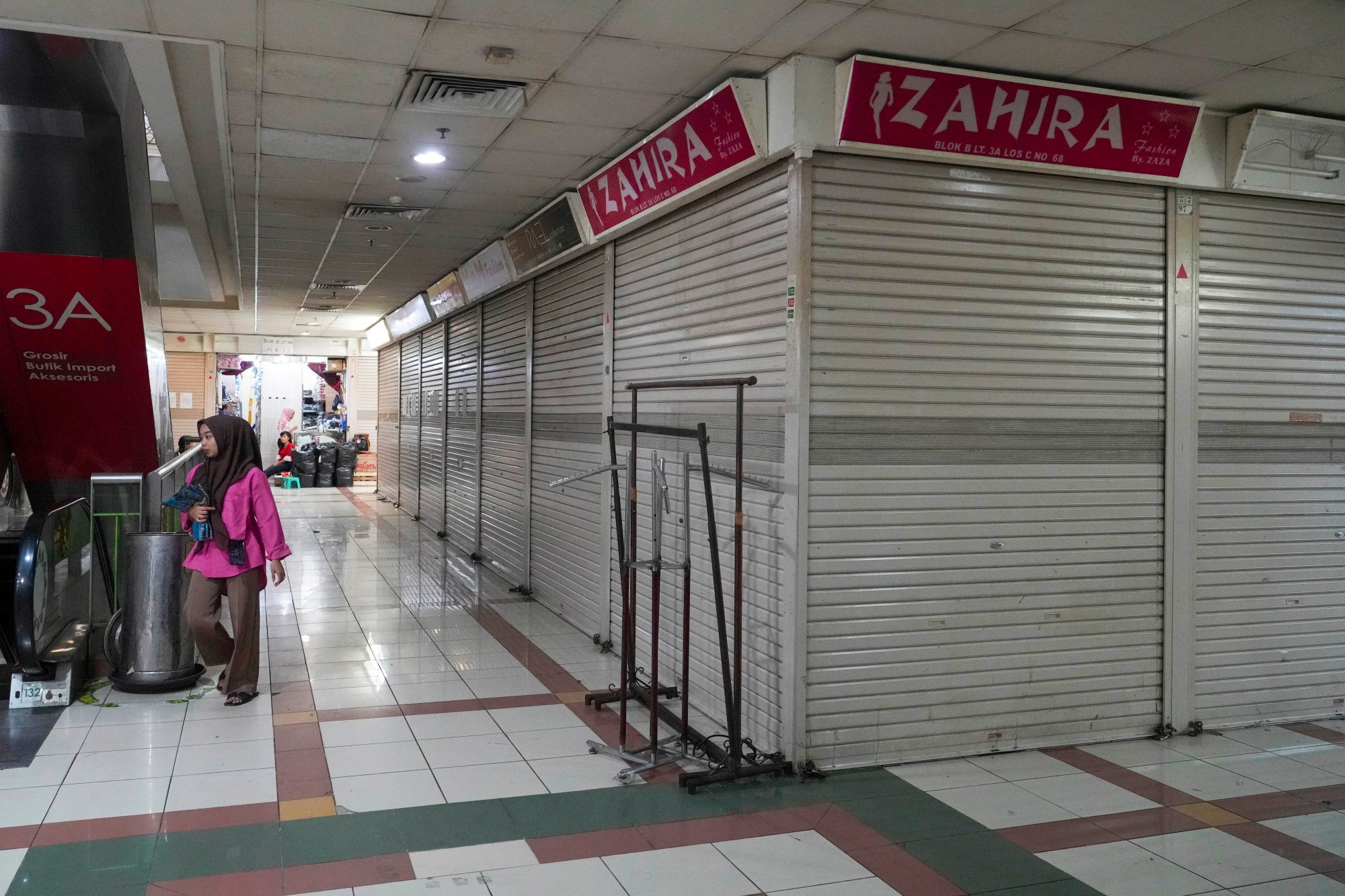 A person walks by closed and deserted shops in the Tanah Abang textile market in Jakarta, Indonesia, on September 28, 2023. Photo: AP