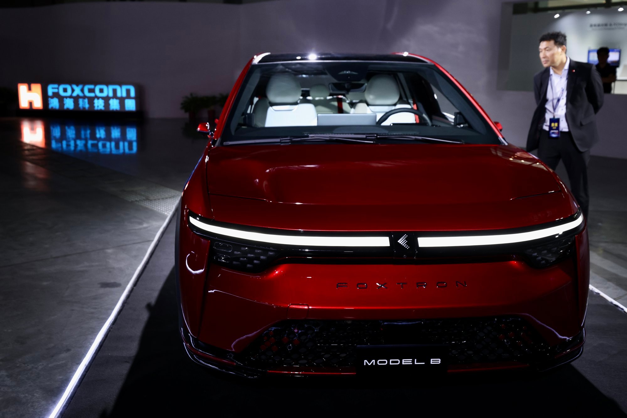 A man inspects the Foxtron Model B electric vehicle, part of a range of EVs made by Foxconn Technology Group, on display during Hon Hai Technology Day in Taipei on October 18, 2023. Photo: EPA-EFE