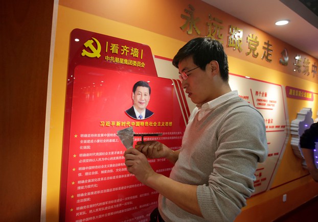ENG_CHN_PatrioticEducation_10202023.2.jpg A worker decorates a party activity room next to a wall with the portrait of Chinese president Xi Jinping promoting his socialist thought with Chinese characteristics at Tidal Star Group headquarters in Beijing, Feb. 25, 2019. Credit: Jason Lee/Reuters