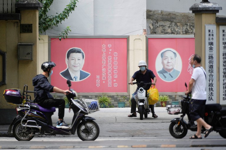 ENG_CHN_PoliticalStruggle_10092023.2.JPG People pass portraits of Chinese President Xi Jinping and late Chinese chairman Mao Zedong In Shanghai, China, Aug. 31, 2022. Credit: Aly Song/Reuters
