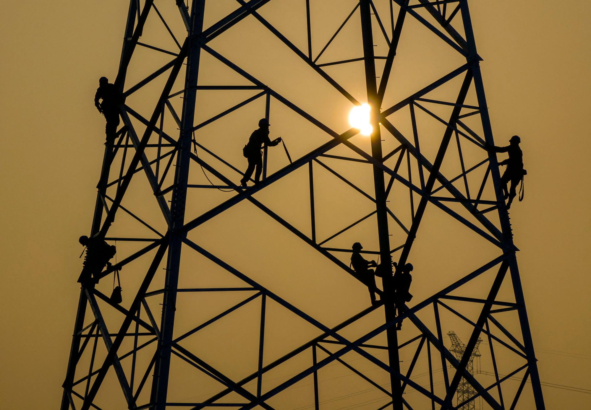 Workers build an electricity transmission tower near Huai’an, in China’s eastern Jiangsu Province on September 7, 2023. Photo: AFP