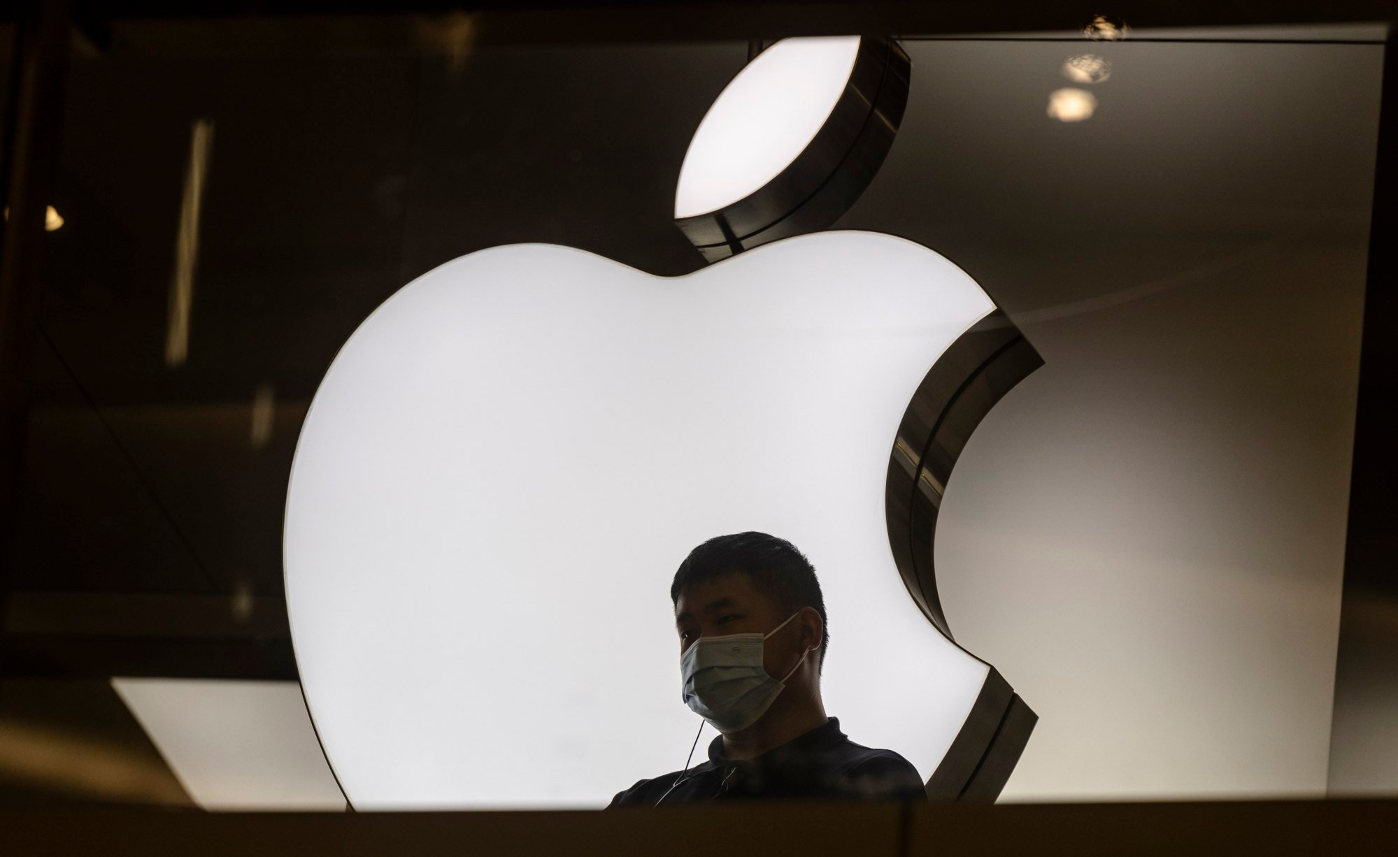 A man stands in front of the Apple store in Shanghai on January 5, 2022. Apple has recently updated guidelines on its Chinese app developer website to reflect the latest government policy that requires the licensing of all apps for local users. Photo: EPA-EFE
