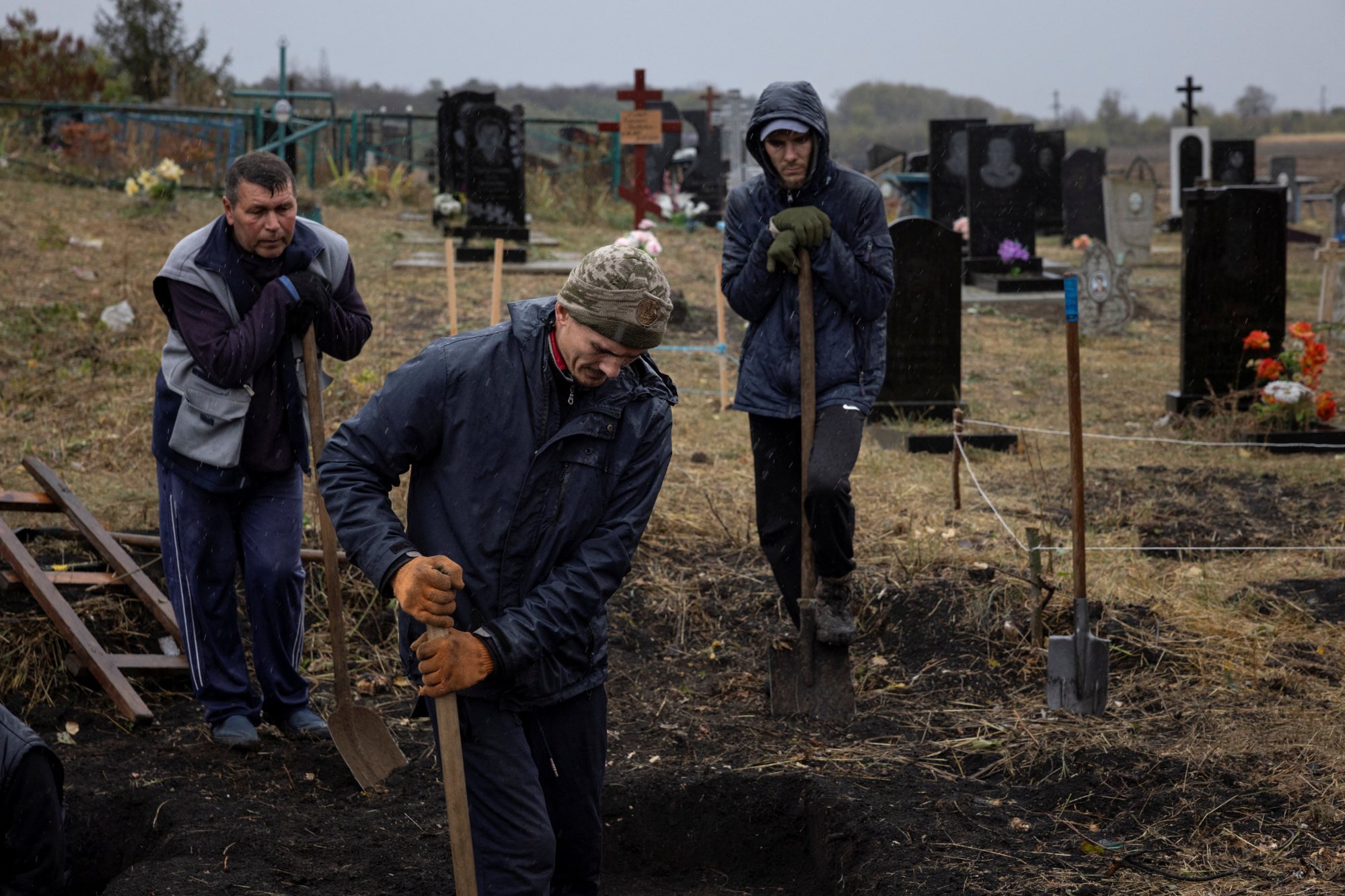 Local residents dig graves at the cemetery in the village of Hroza, near Kharkiv, Ukraine, on Saturday. The day before, 52 people were killed when Russian missiles struck a house full of people mourning other losses in the war. Photo: Reuters