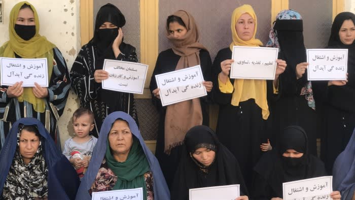 Afghan women hold placards in a protest to demand their right to education