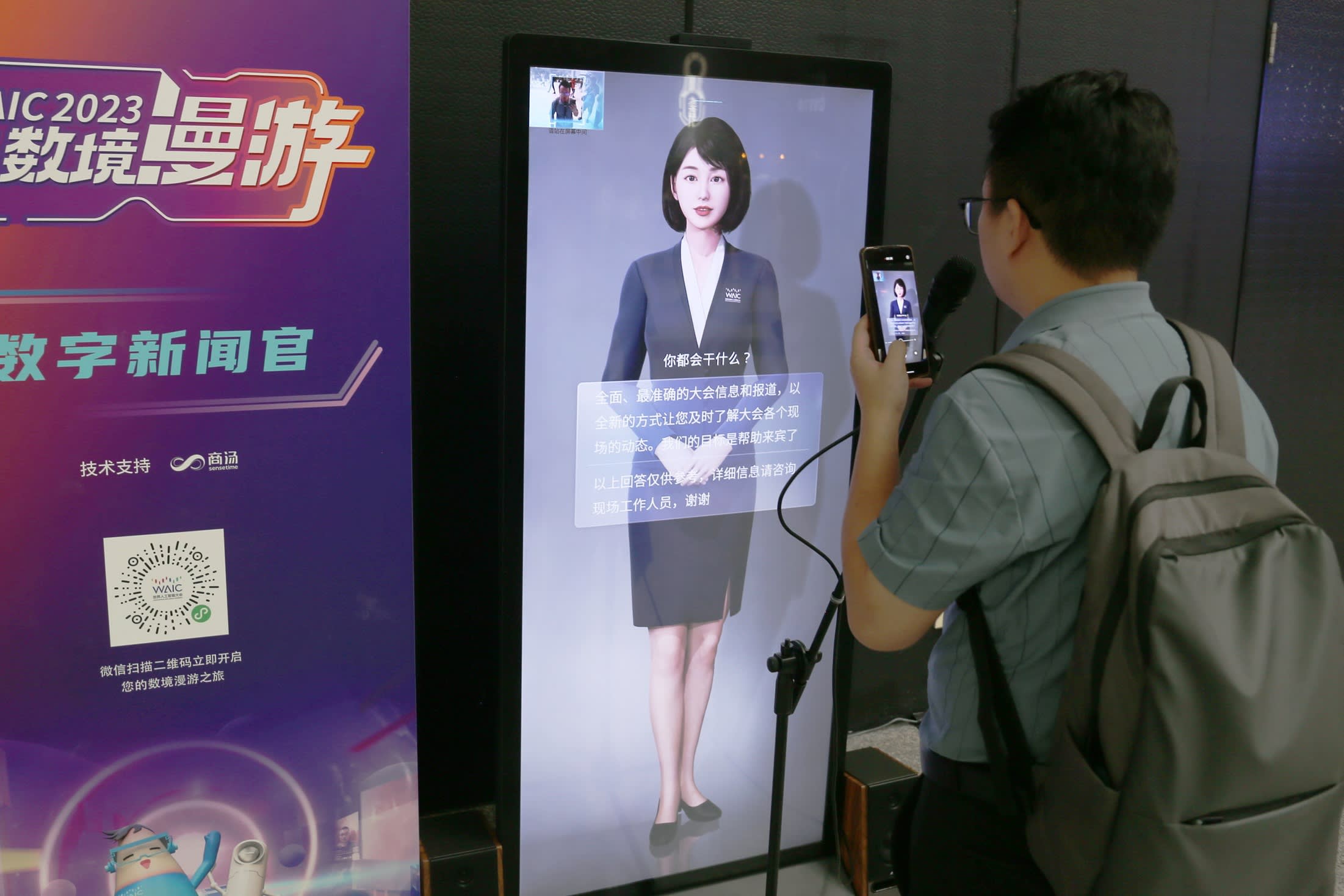 A person photographs a digital news officer produced by SenseTime
