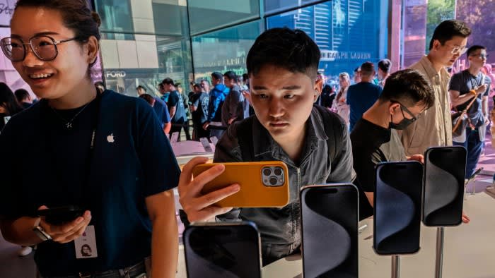 A man takes a photo of an iPhone 15 in Beijing. Apple is hedging its bets via the ‘China plus one’ strategy