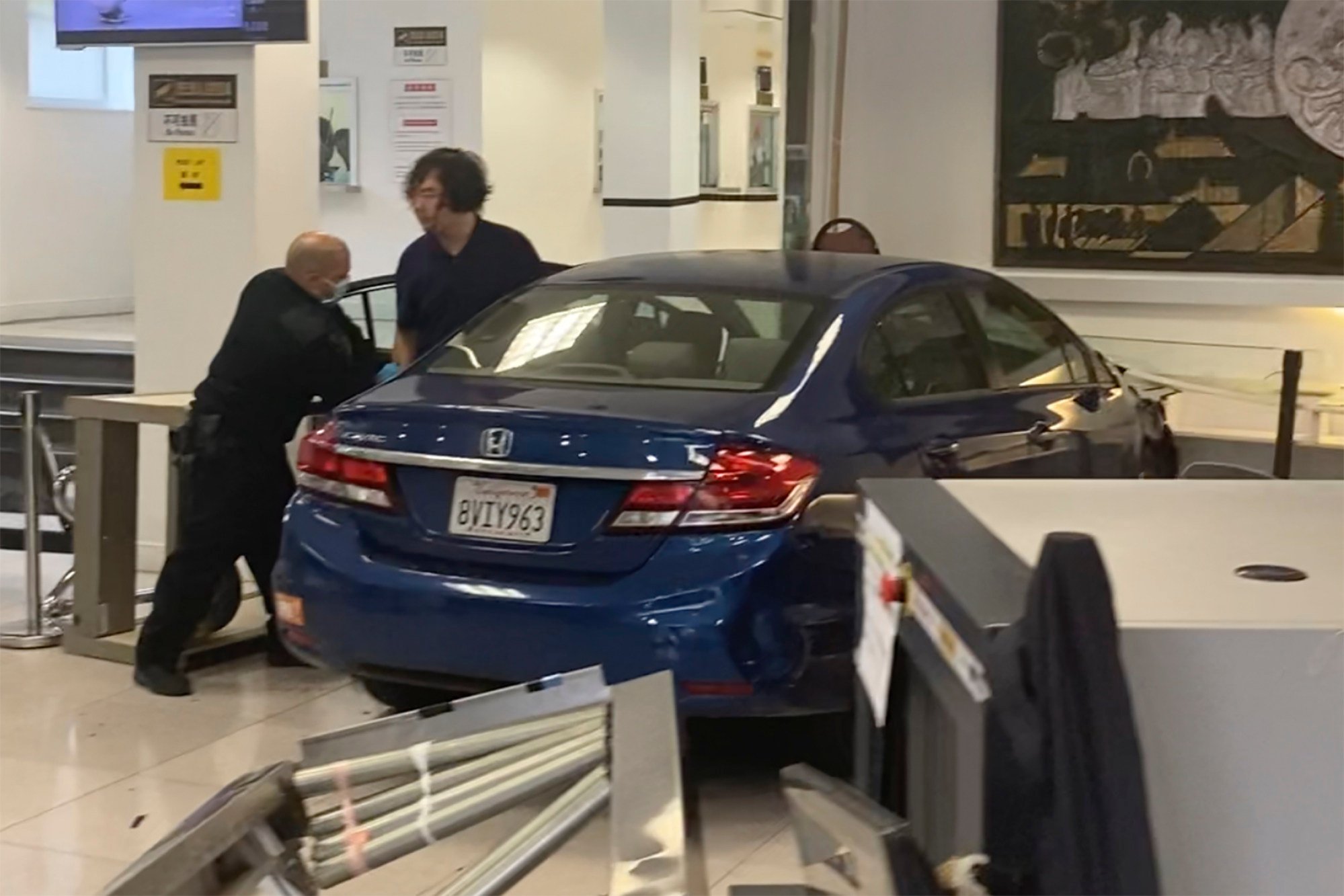 A man gets out of his car after crashing into the lobby of the Chinese consulate in San Francisco on October 9. Photo: Sergii Molchanov via AP