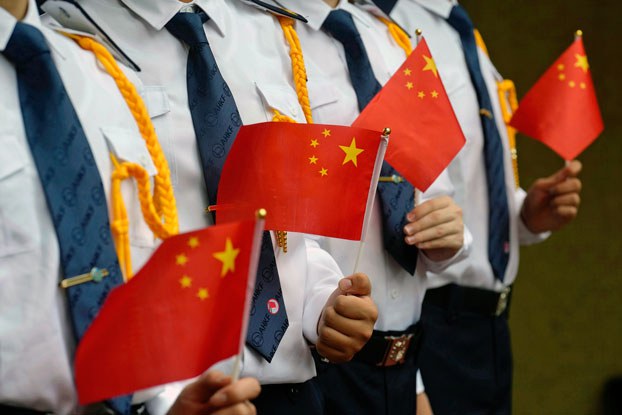ENG_CHN_HKUKBabies_11082023.3.jpg Students hold Chinese national flags during a flag raising ceremony at a school in Hong Kong, July 1, 2021. Credit: Vincent Yu/Associated Press