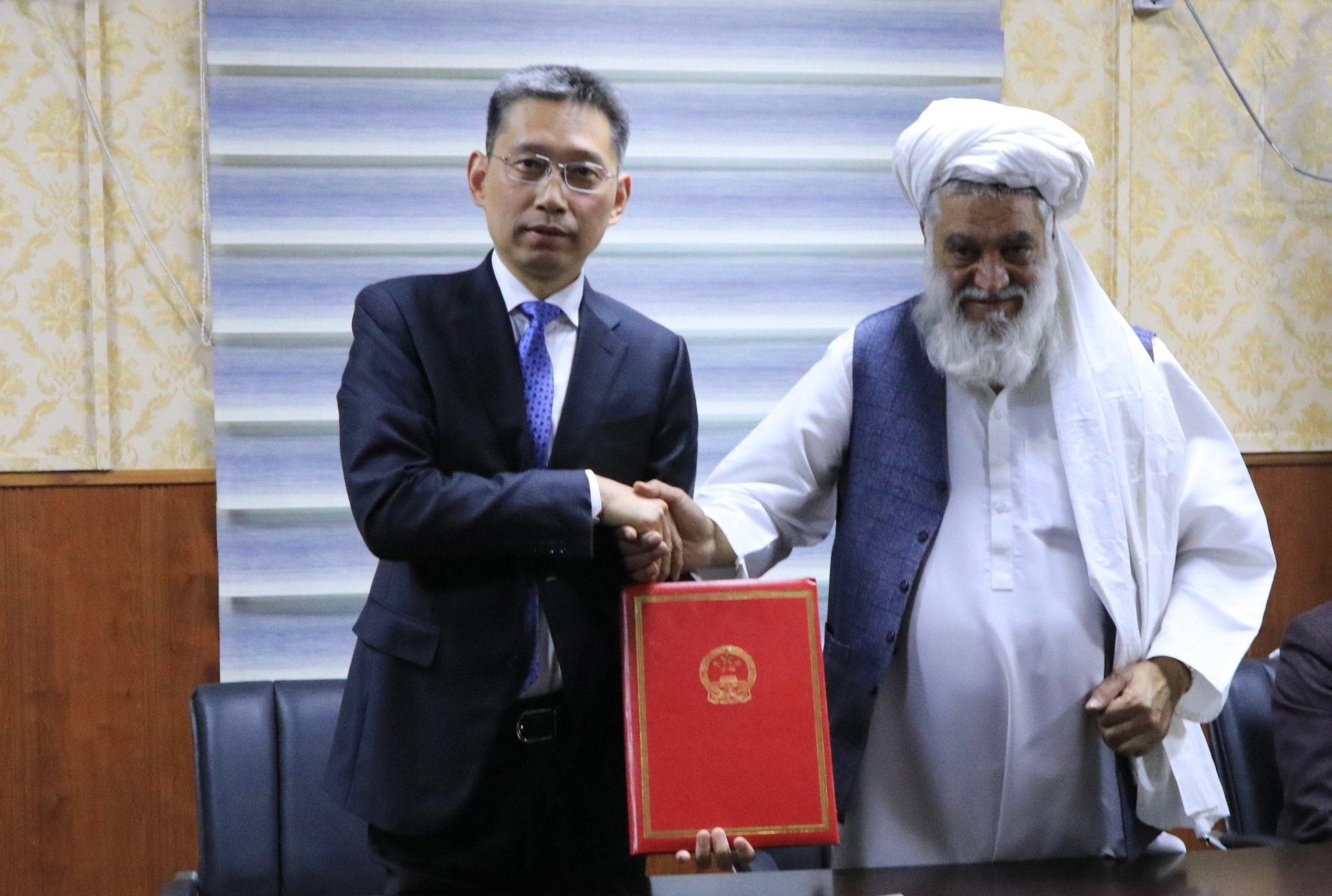Chinese ambassador to Afghanistan Zhao Xing, left, shakes hands with Mohammad Abas Akhund, acting minister for Afghanistan’s National Disaster Management Authority, during a handover ceremony for earthquake relief materials. Photo: Xinhua