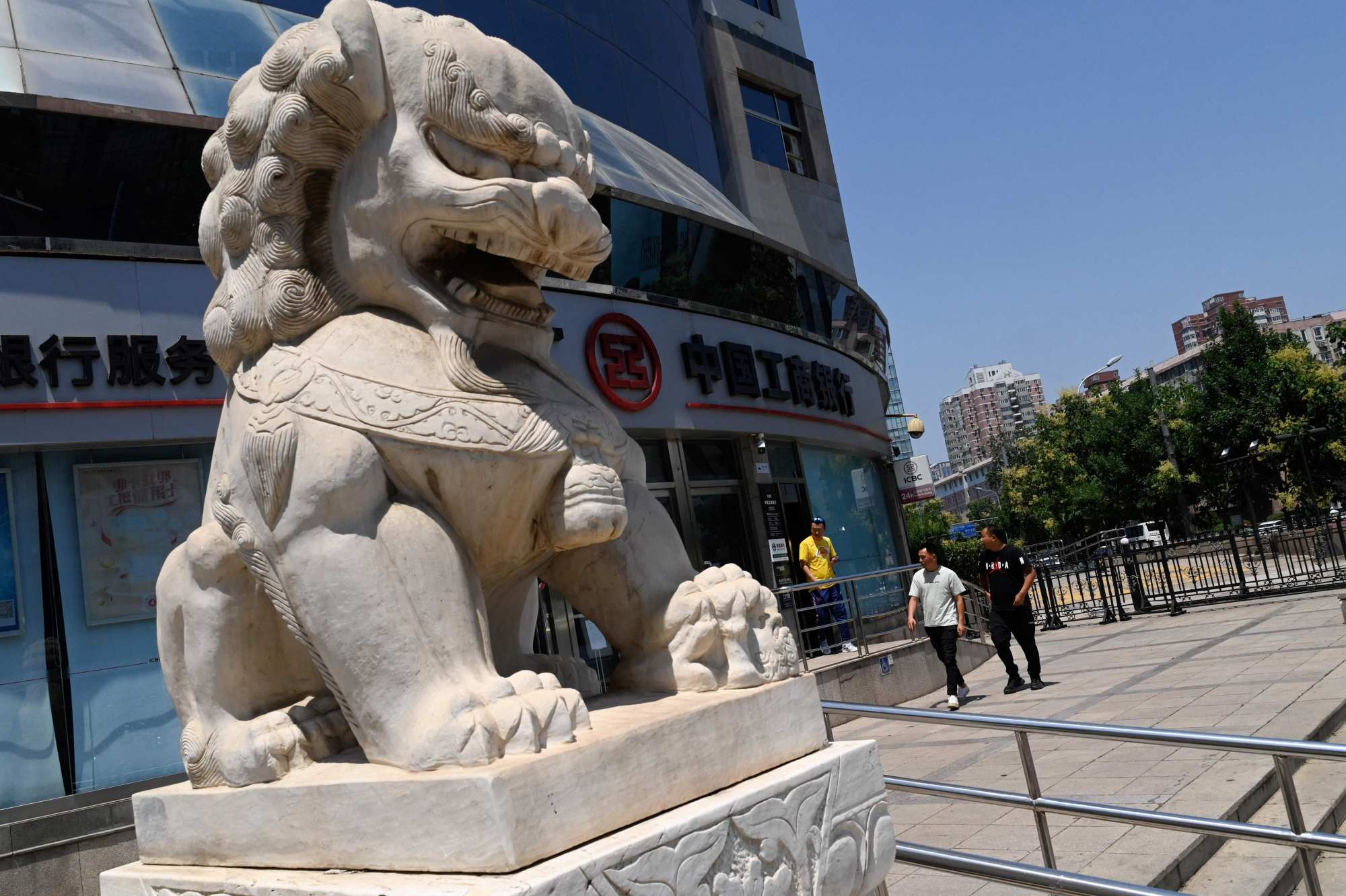 People walk past an ICBC bank branch in Beijing on June 15, 2023. Photo: AFP