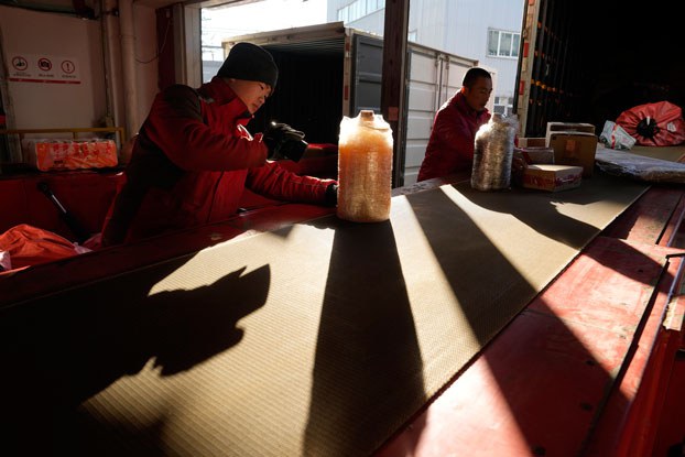 ENG_CHN_EconomicWoes_11292023.2.jpg Workers sort parcels at a distribution center for e-commerce platform JD.com in Beijing, China, Nov. 11, 2023. (Ng Han Guan/AP)